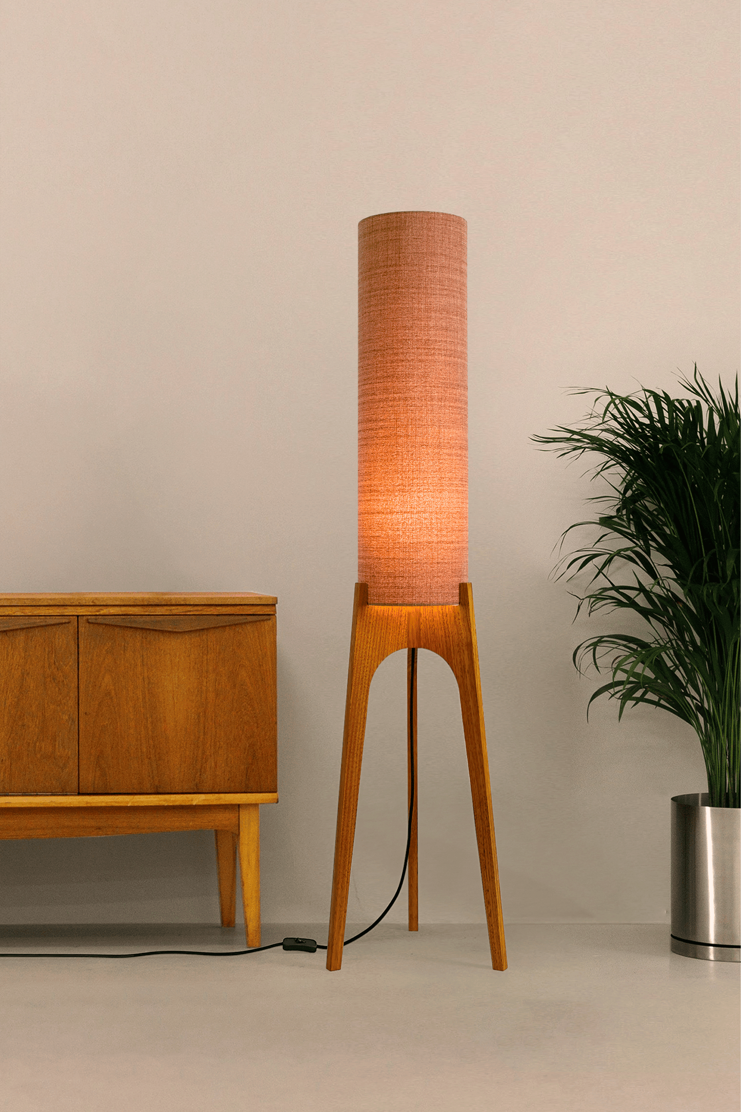 The Clay Archie Rocket Floor Lamp by Retro Duo, featuring a handcrafted wooden base and Clay cylindrical shade, styled beside a wooden cabinet and plant against a light grey background.