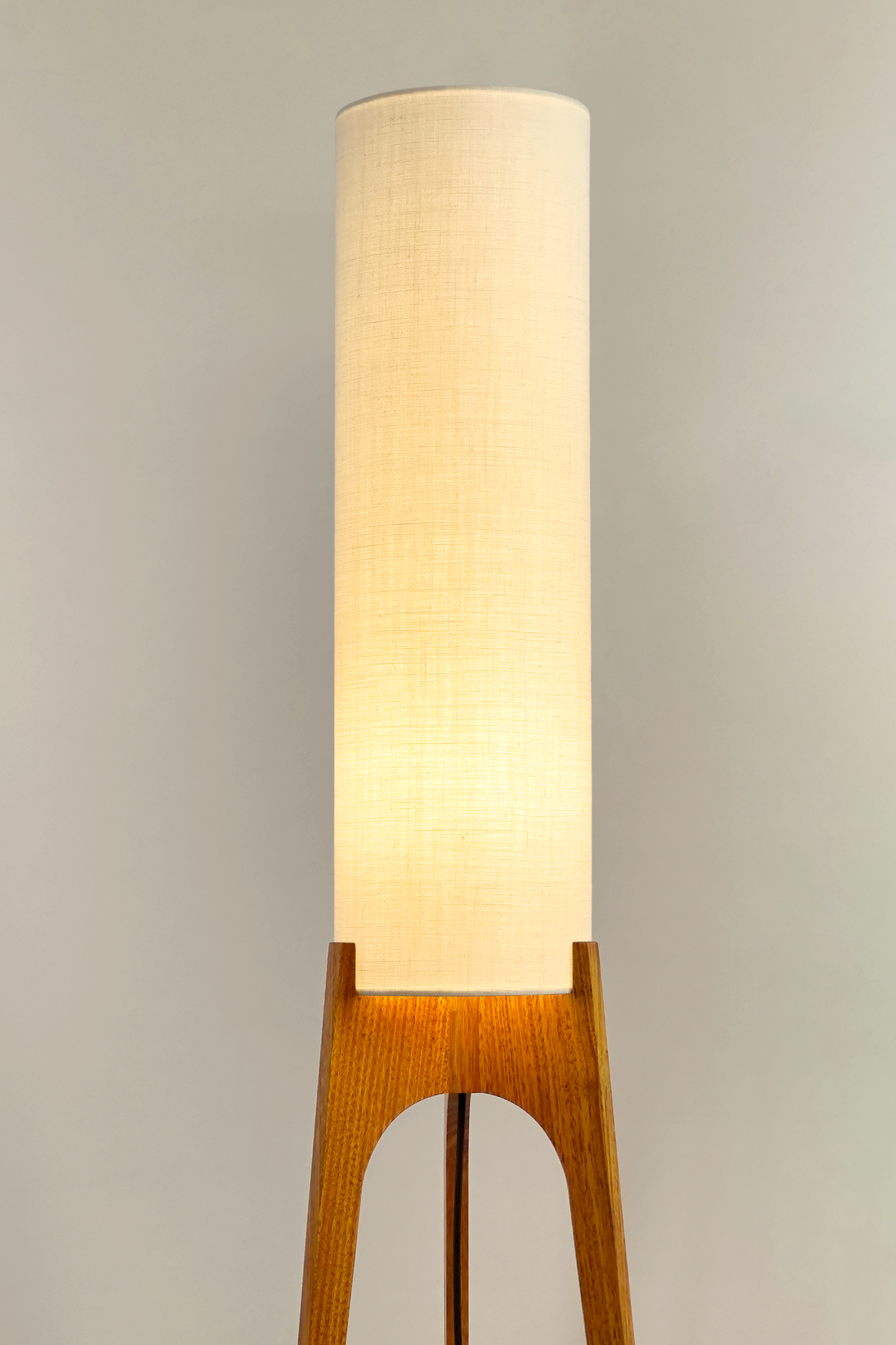Cotton – Premium Linen Archie Rocket Floor Lamp with a beige shade next to a wooden cabinet and plant on a neutral background. Clean, airy, and effortlessly versatile, its soft tone brings calm and clarity to any space.