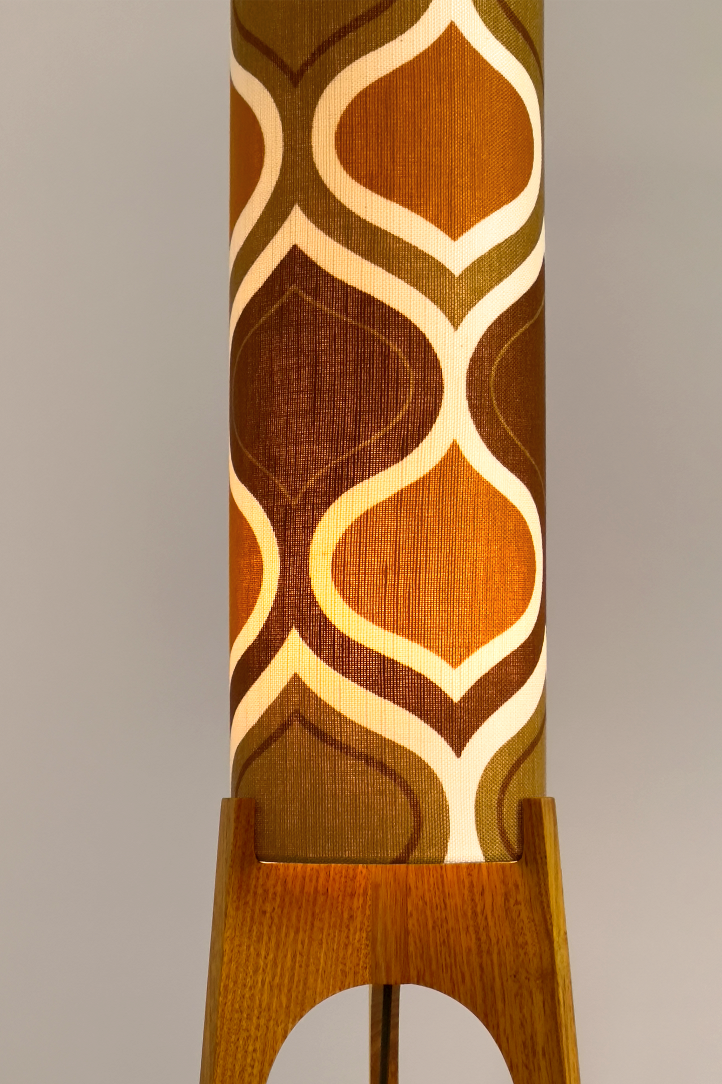 The Honey Mustard Archie Rocket Floor Lamp is a playful nod to the geometric patterns of the 1970s. Handcrafted from authentic vintage fabric and hardwood oak next to a wooden cabinet and plant.