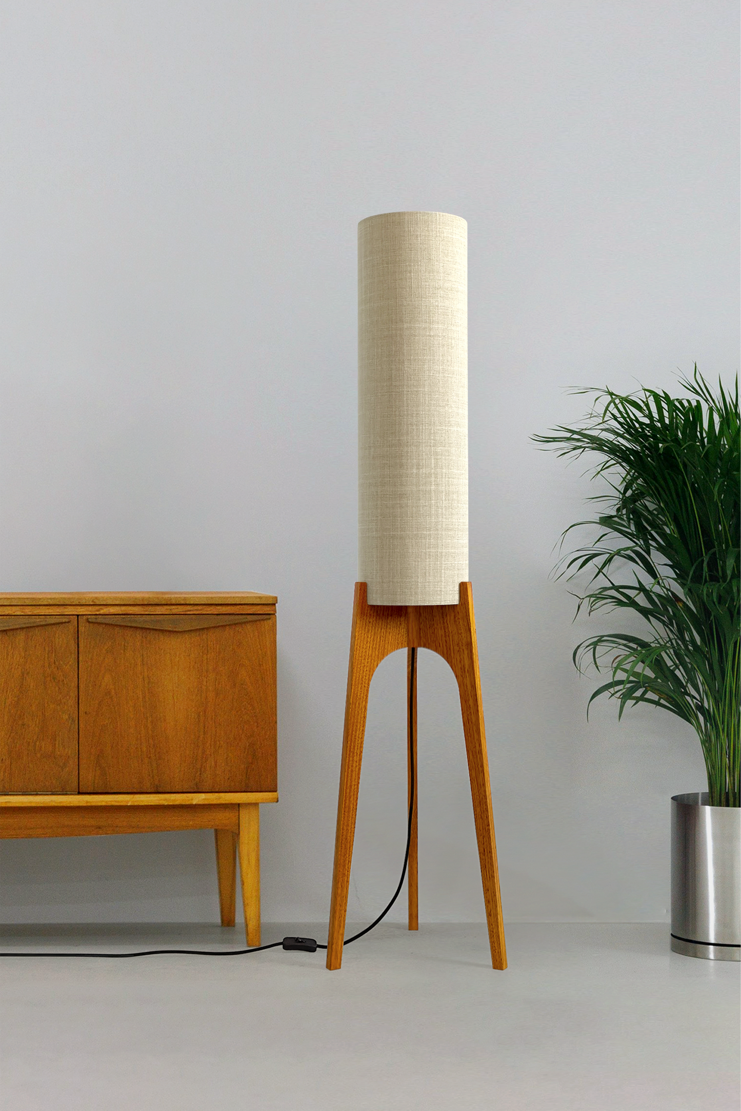 Ivory - Archie Rocket Floor Lamp handmade by Retro Duo. A soft, natural and timeless wooden floor lamp with a cylindrical shade in a room with a cabinet and a plant.