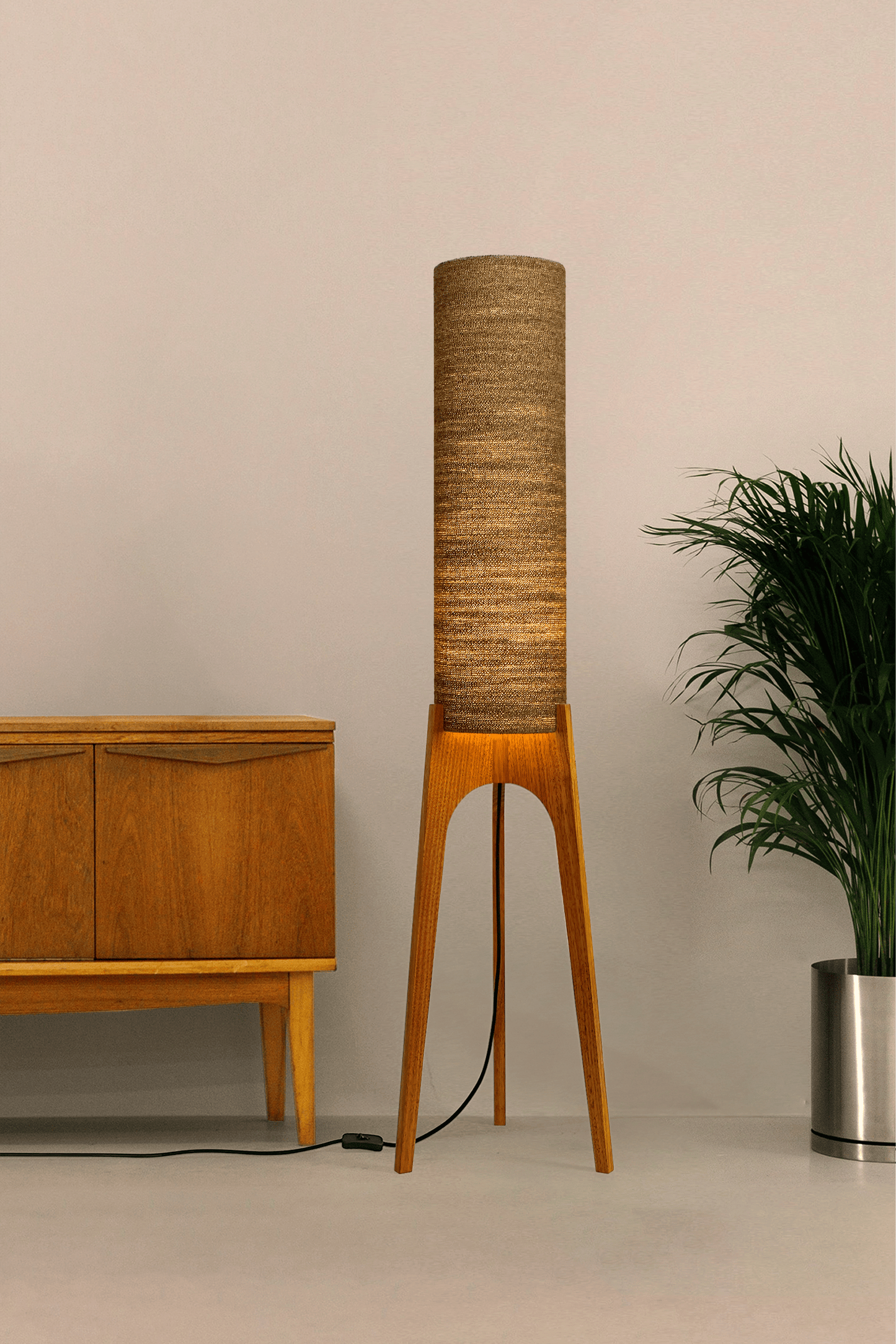 a handmade Rocket Floor Lamp with a woven lampshade in brown and a wooden lamp base in a mid-century room setting