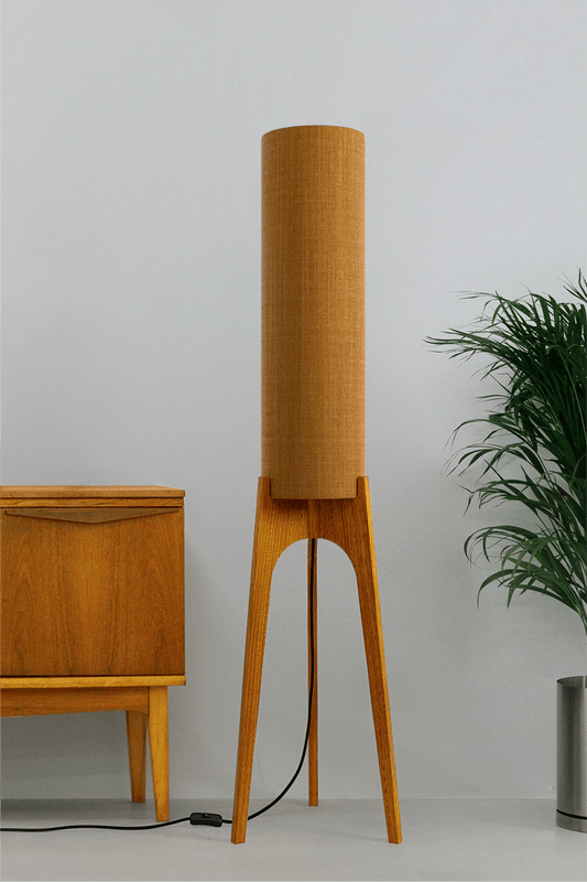 Mustard. Archie Rocket Floor Lamp - a handcrafted wooden floor lamp with a cylindrical shade in a mustard colour in a minimalist room.