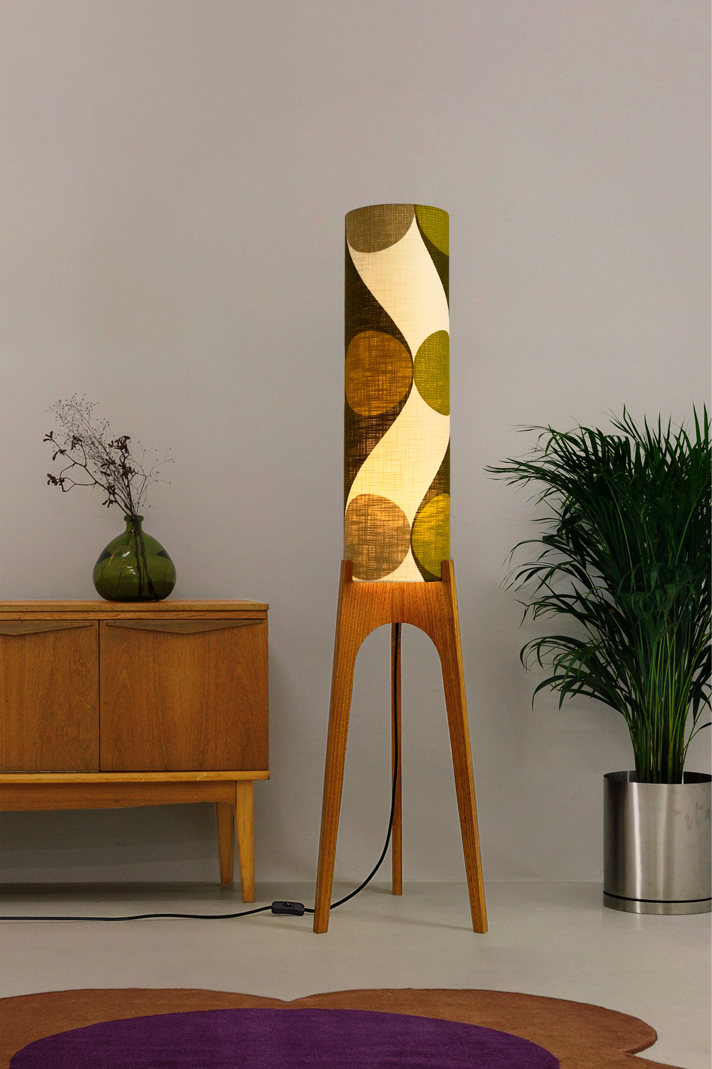 Olli - Archie Rocket Floor Lamp handmade by Retro Duo, from vintage geometric patterned fabric lampshade and wooden lamp base in a room with a wooden cabinet and plant.