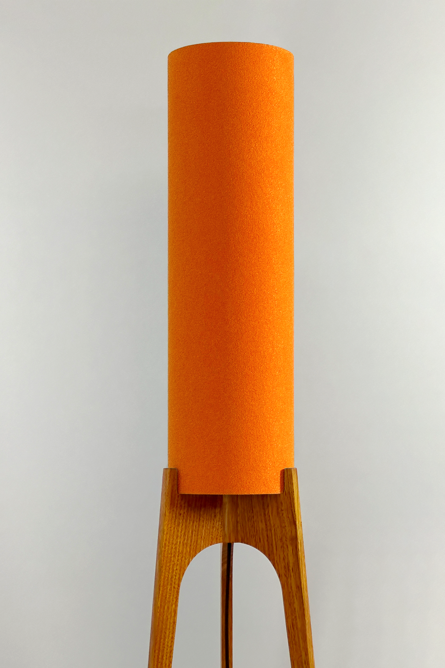 Orange - Archie Rocket Floor Lamp | Handmade by RETRO DUO with a cylindrical lampshade and wooden lamp base next to a cabinet & plant