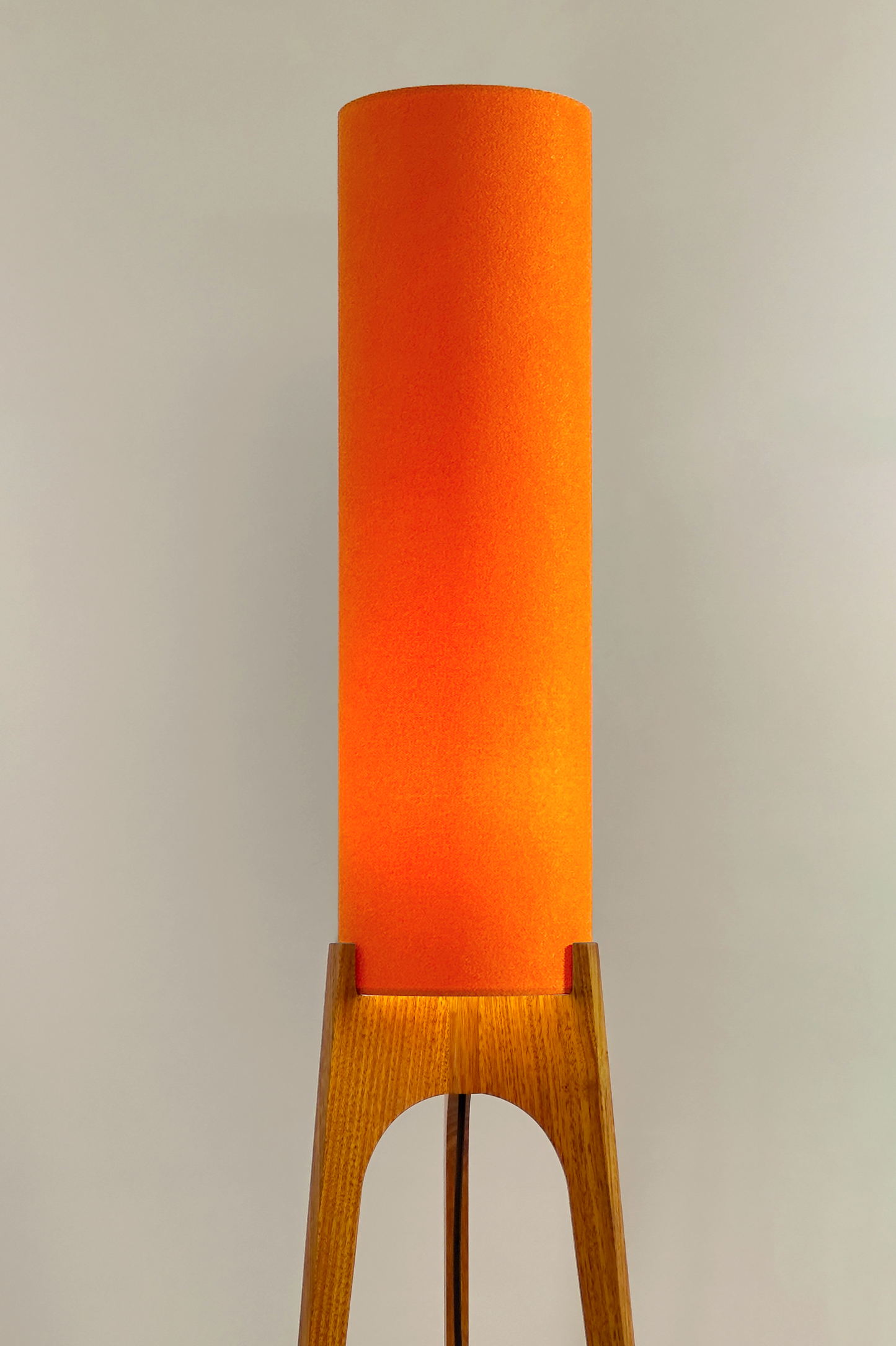 Orange - Archie Rocket Floor Lamp | Handmade by RETRO DUO with a cylindrical lampshade and wooden lamp base next to a cabinet & plant