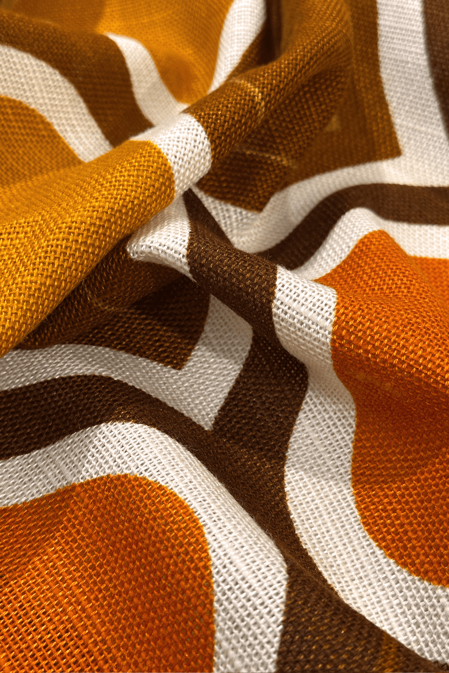 Patterned fabric with geometric design in brown, orange, and white on a black background