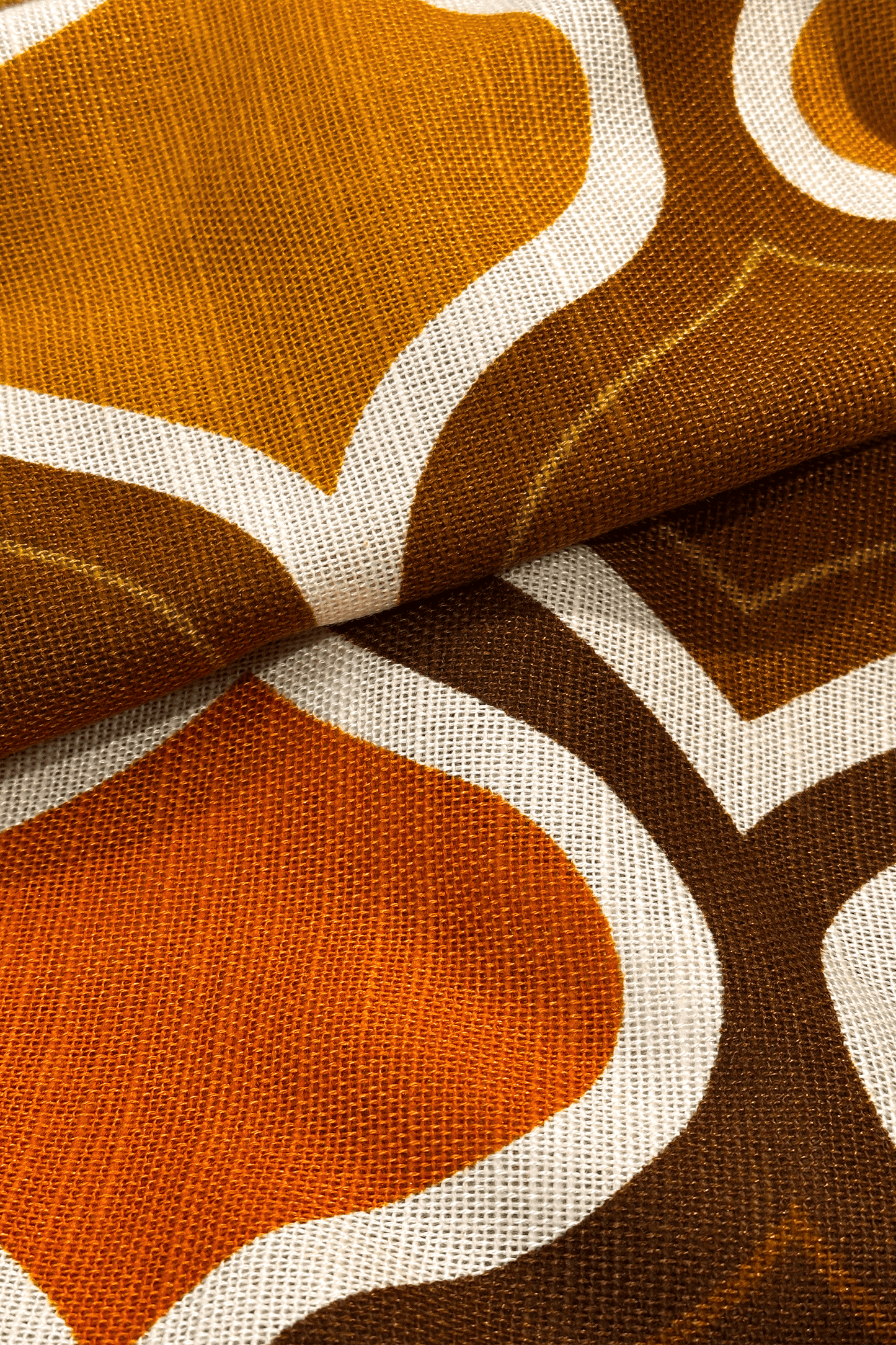 Patterned fabric with geometric design in brown, orange, and white.