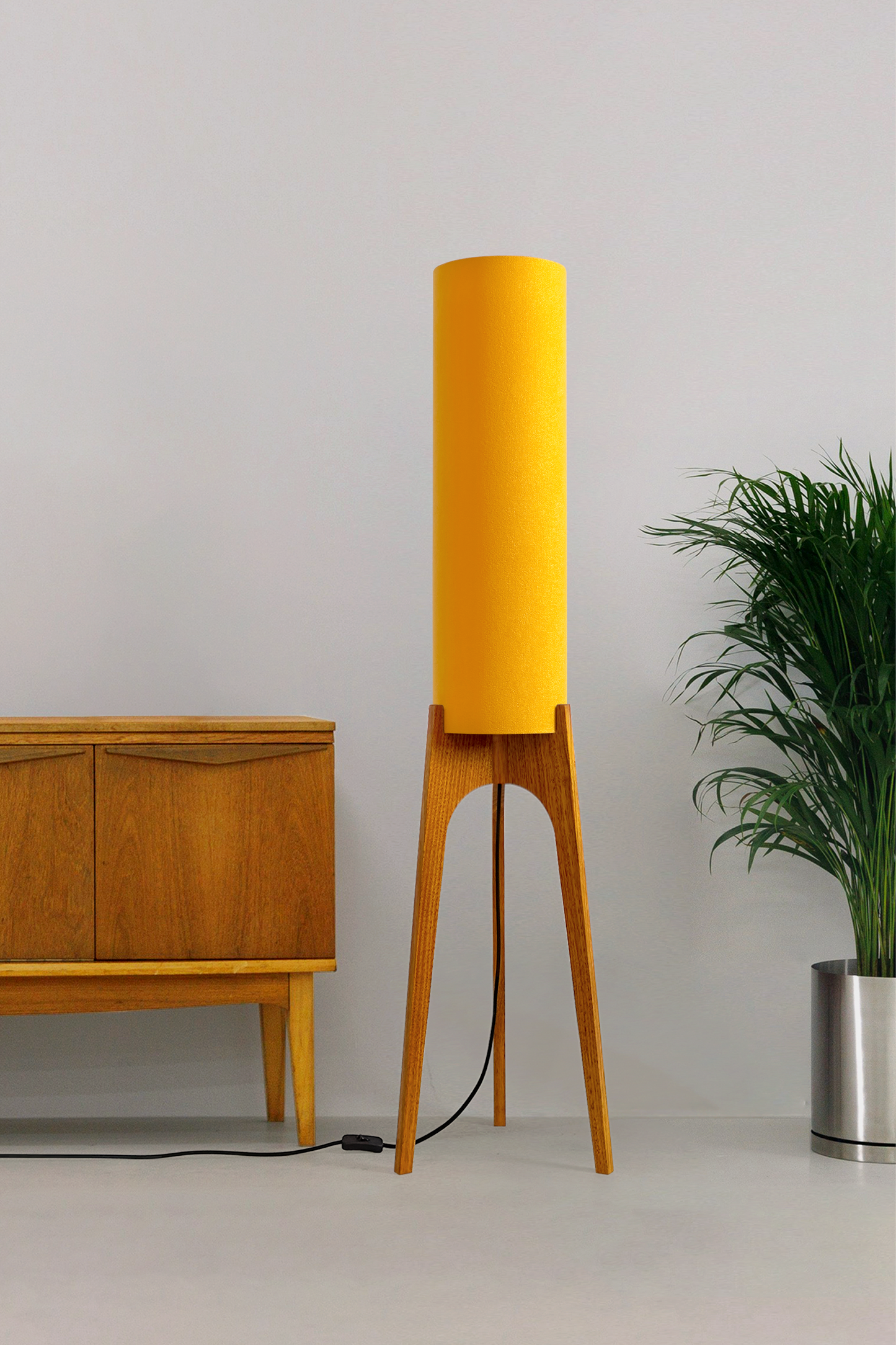 Yellow rocket floor lamp with wooden base against a wall