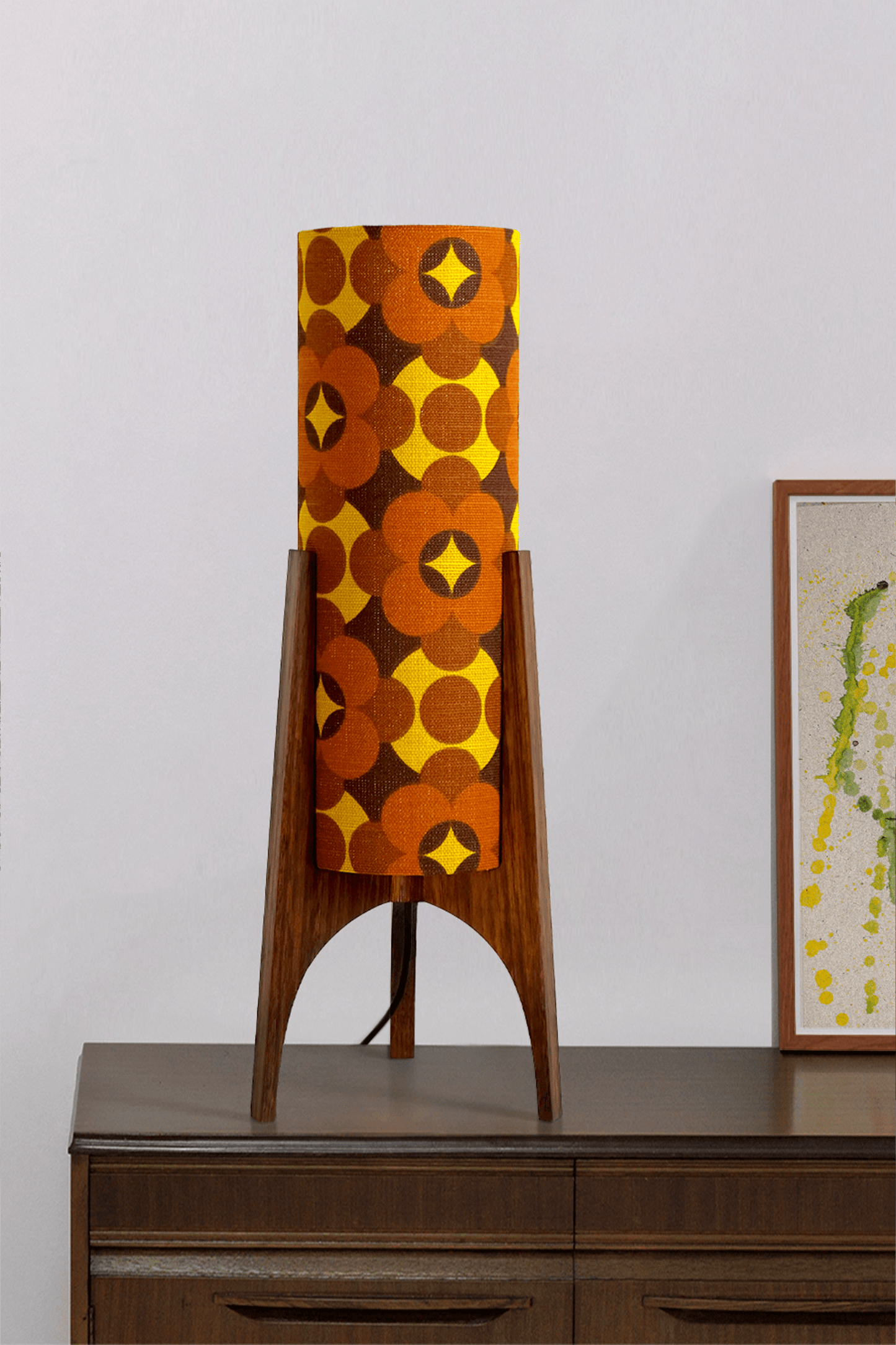 Coco - Archie Rocket Table lamp with a vintage geometric patterned fabric shade on a wooden cabinet against a white wall.