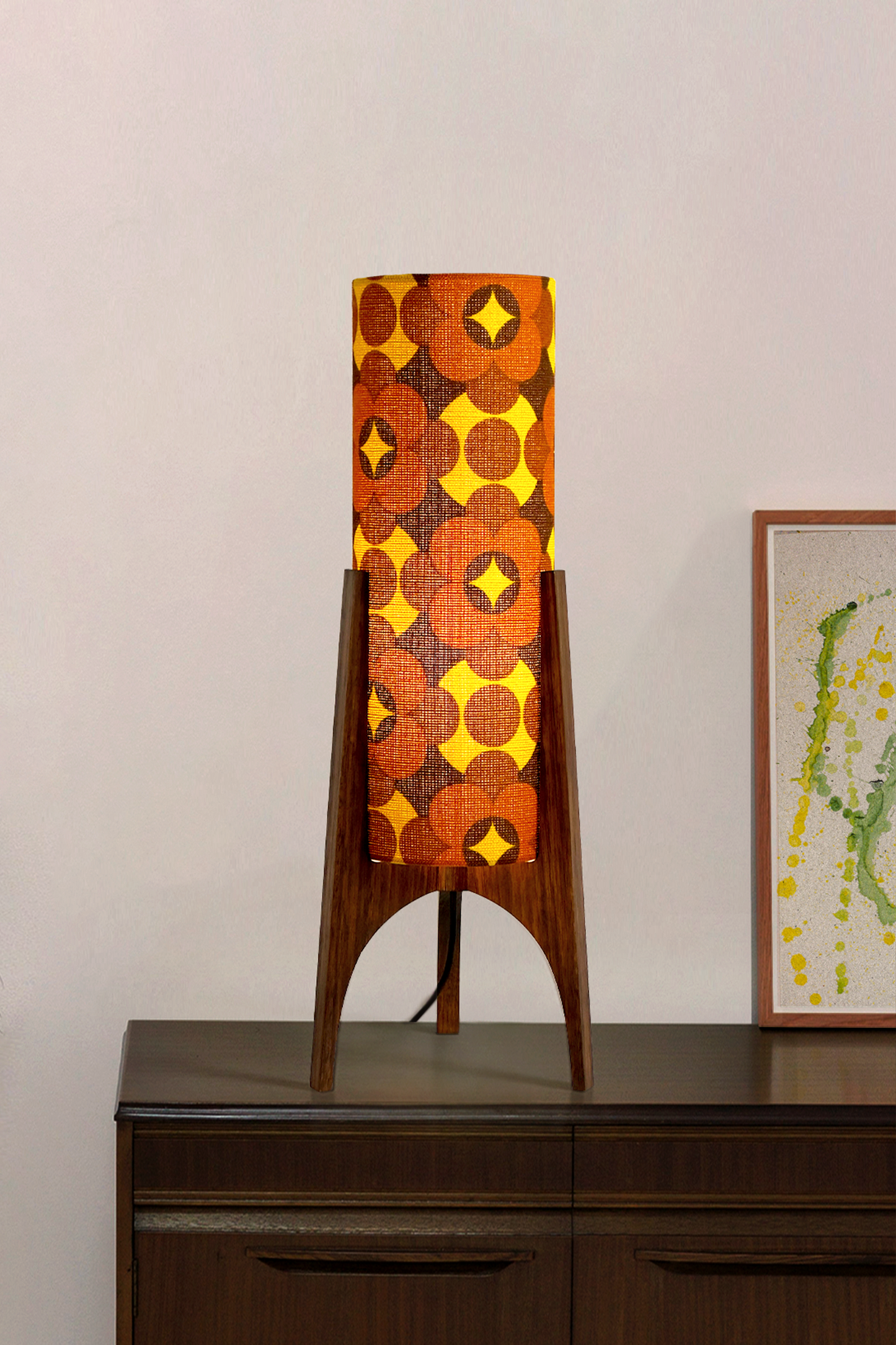Coco - Archie Rocket Table lamp with a vintage geometric patterned fabric shade on a wooden cabinet against a white wall.