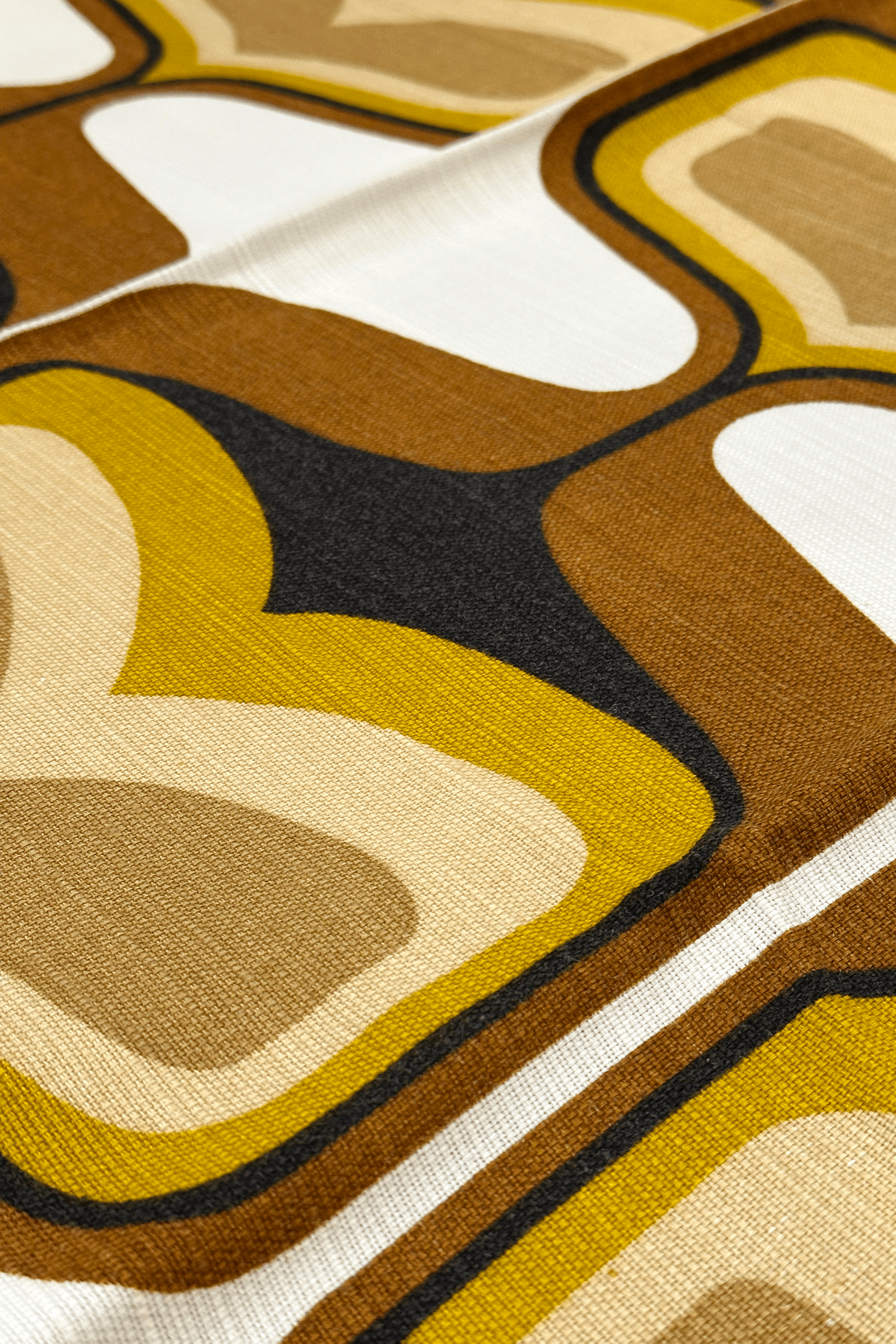 Bruno - Close-up of patterned vintage geometric fabric with brown, yellow, and white colors.