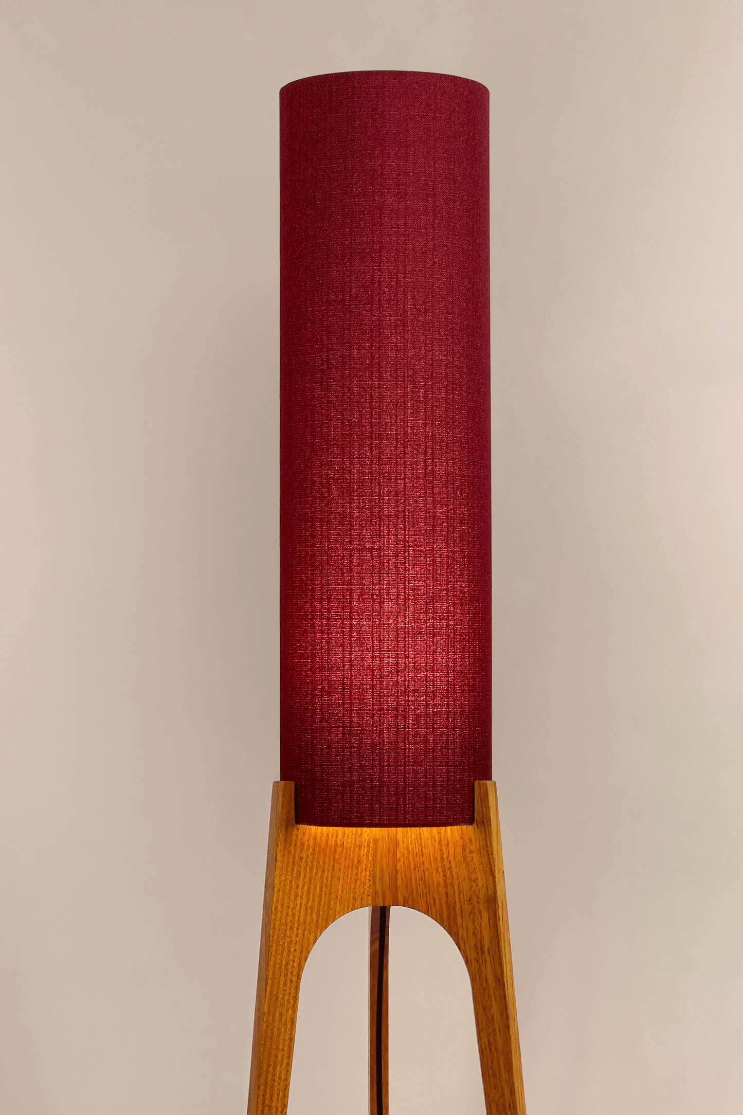 Wooden rocket floor lamp with a Burgundy cylindrical lampshade handmade from recycled fabric, on a neutral background