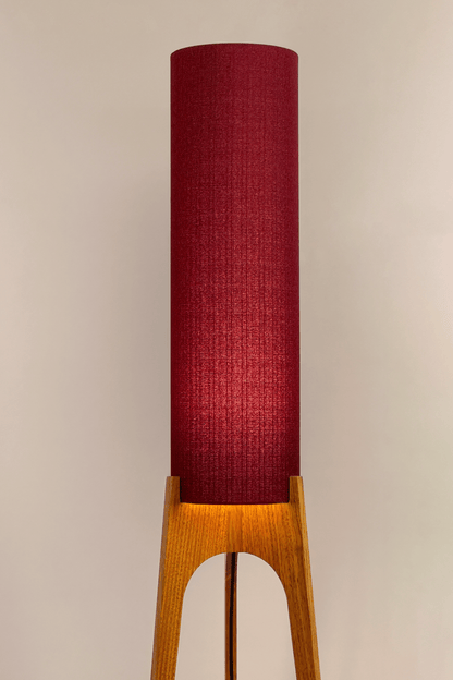 Wooden rocket floor lamp with a Burgundy cylindrical lampshade handmade from recycled fabric, on a neutral background