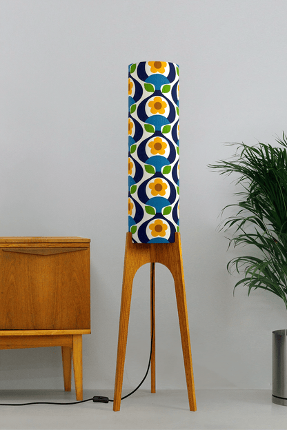 Wooden rocket floor lamp with a colourful geometric patterned lampshade handmade from authentic 70's vintage fabric on a plain background