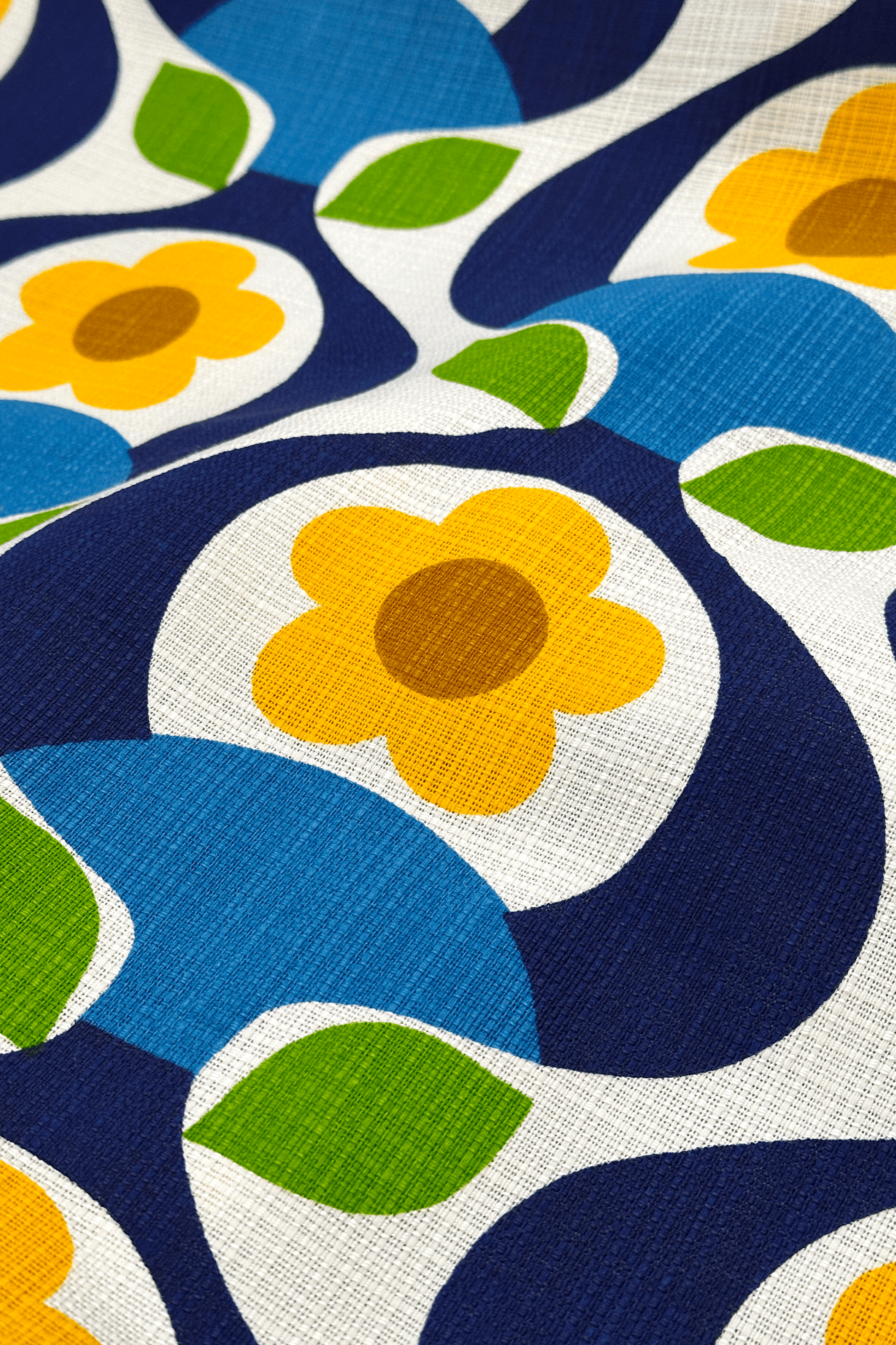 Close-up of a fabric with a colorful floral pattern featuring blue, yellow, green, and brown.