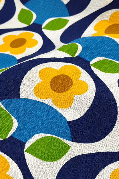 Close-up of a fabric with a colorful floral pattern featuring blue, yellow, green, and brown.