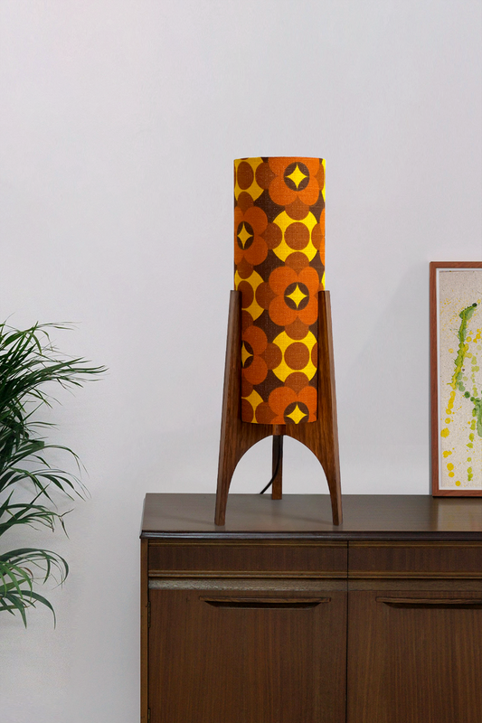 Coco - Archie Rocket Table lamp with a vintage geometric patterned fabric shade on a wooden cabinet against a white wall.