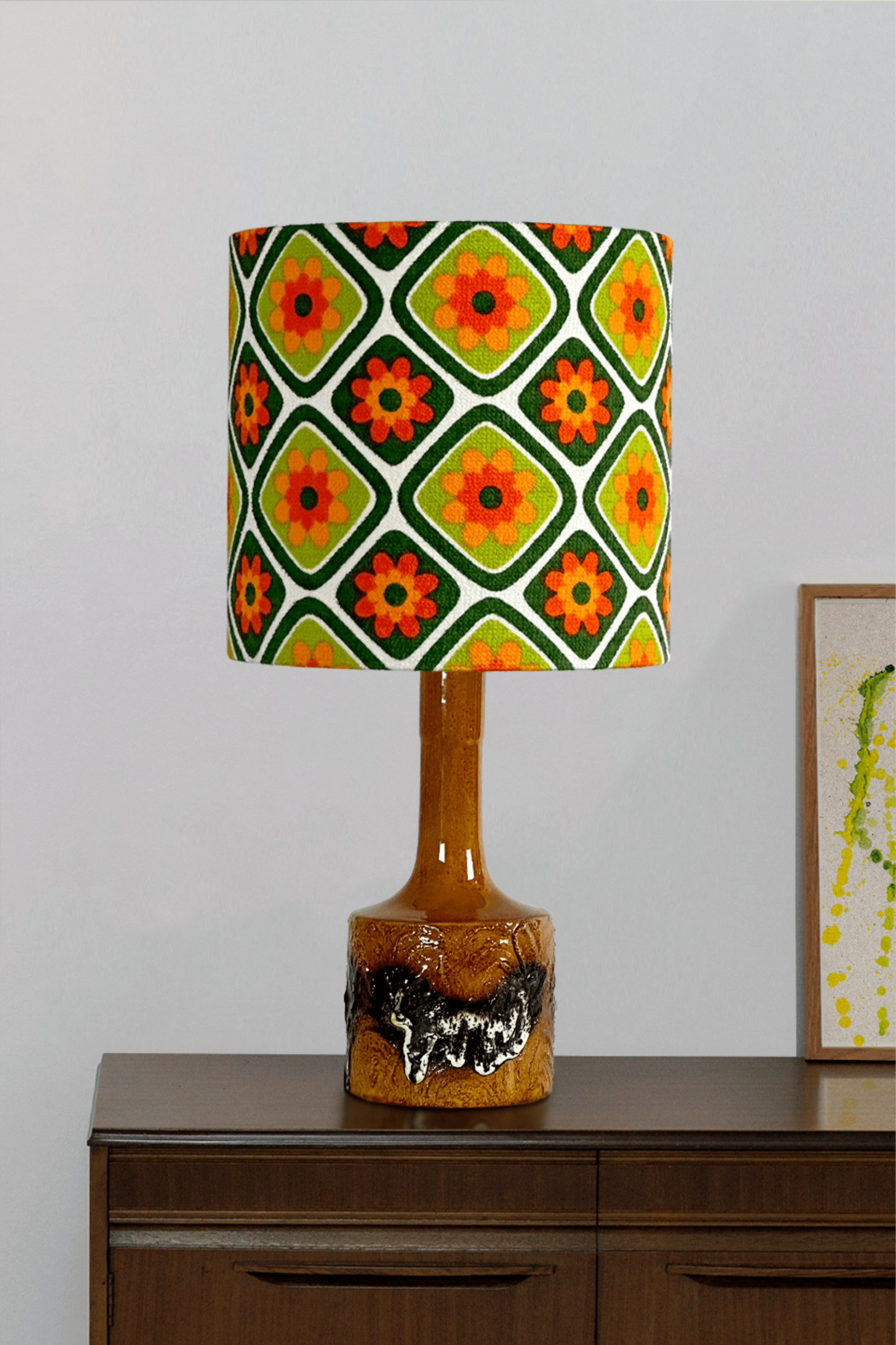 Decorative lamp with a colorful geometric patterned shade on a wooden cabinet.