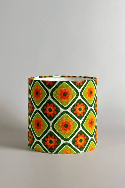 Cylindrical fabric lampshade with a geometric floral pattern on a plain background