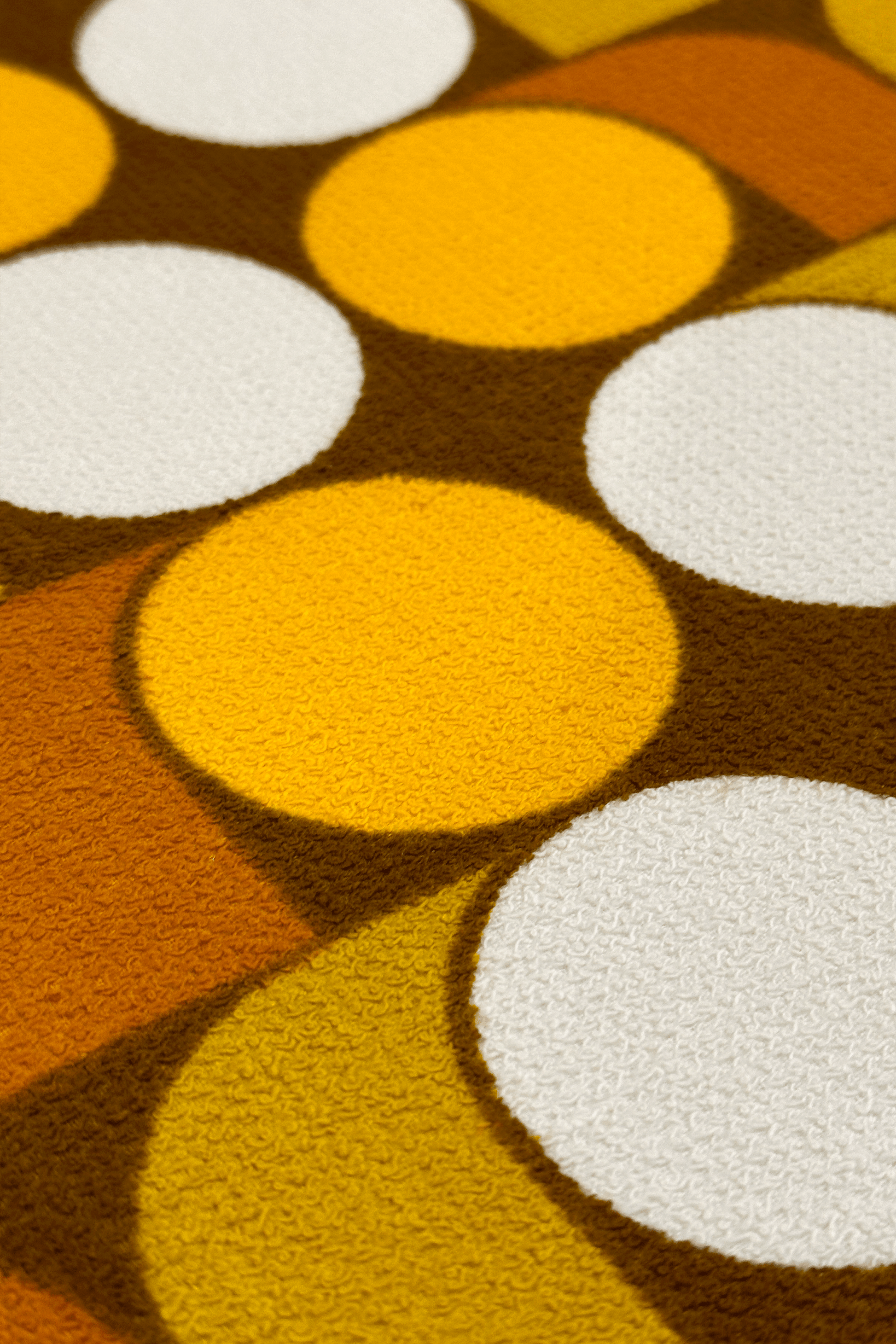 Vintage terry cloth fabric featuring egg-yolk yellow, mustard, warm brown, and soft cream tones, the pattern brings together rhythmic circles and curved geometric forms