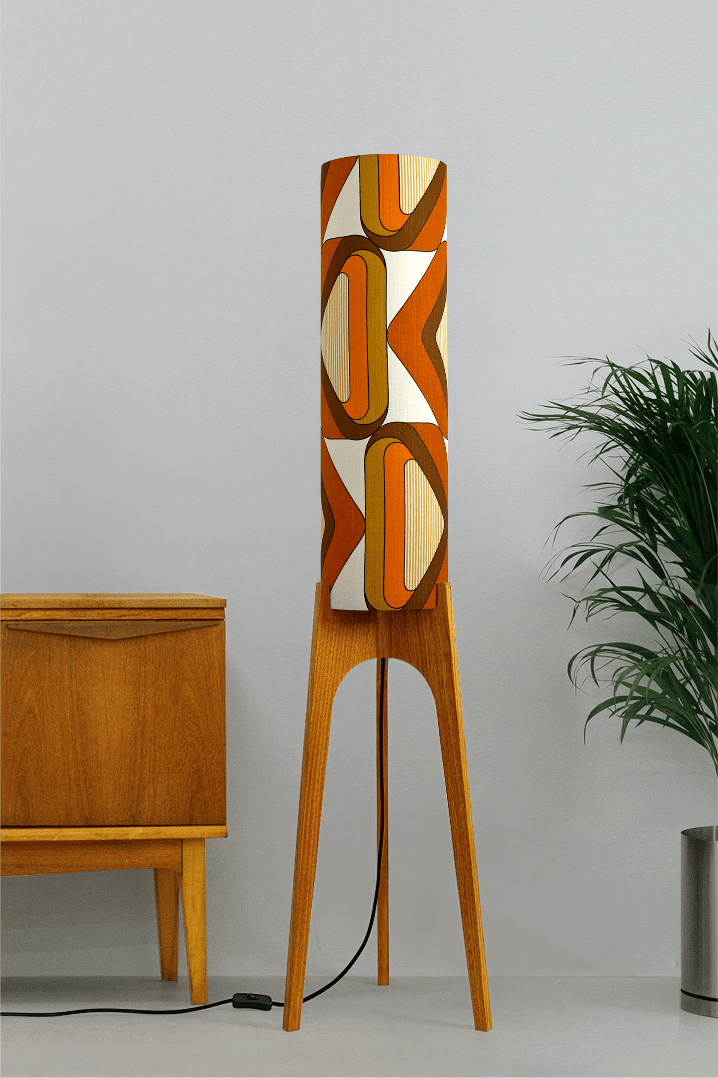 Wooden rocket floor lamp with a handmade lampshade in vintage geometric patterned fabric on a plain background
