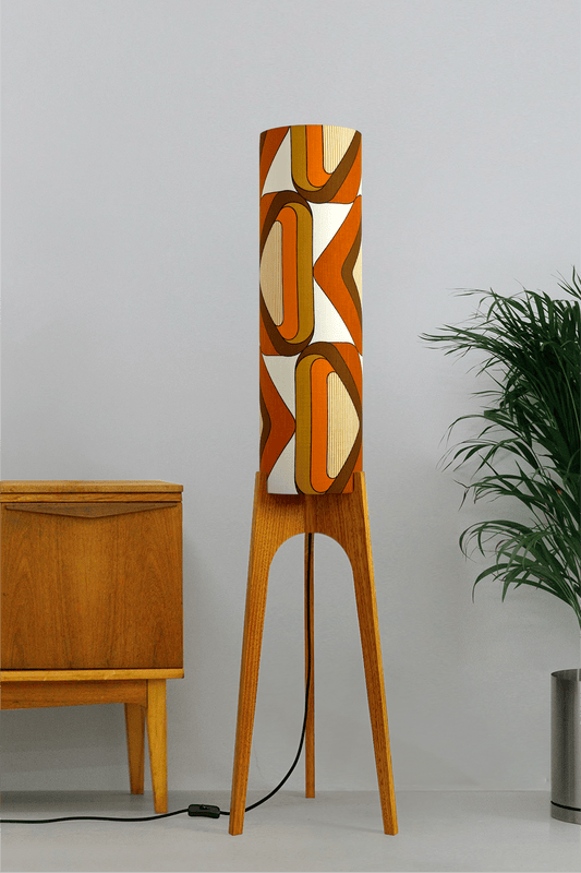 Wooden rocket floor lamp with a handmade lampshade in vintage geometric patterned fabric on a plain background
