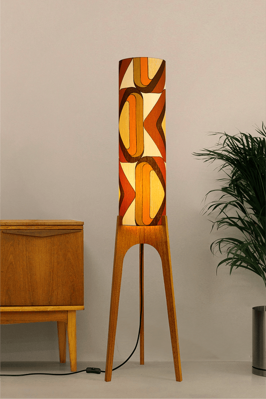 Wooden rocket floor lamp with a handmade lampshade in vintage geometric patterned fabric on a plain background
