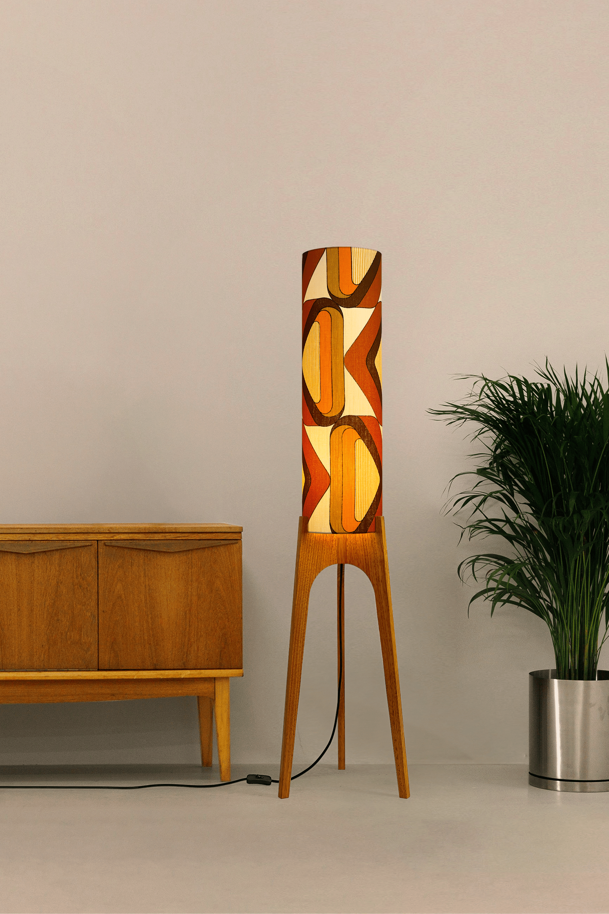 Wooden rocket floor lamp with a handmade lampshade in vintage geometric patterned fabric on a plain background