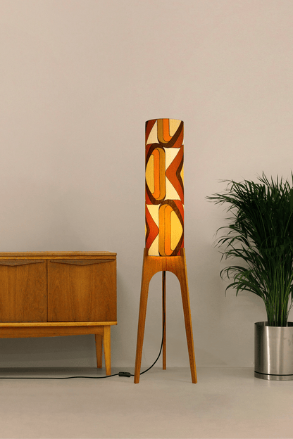 Wooden rocket floor lamp with a handmade lampshade in vintage geometric patterned fabric on a plain background