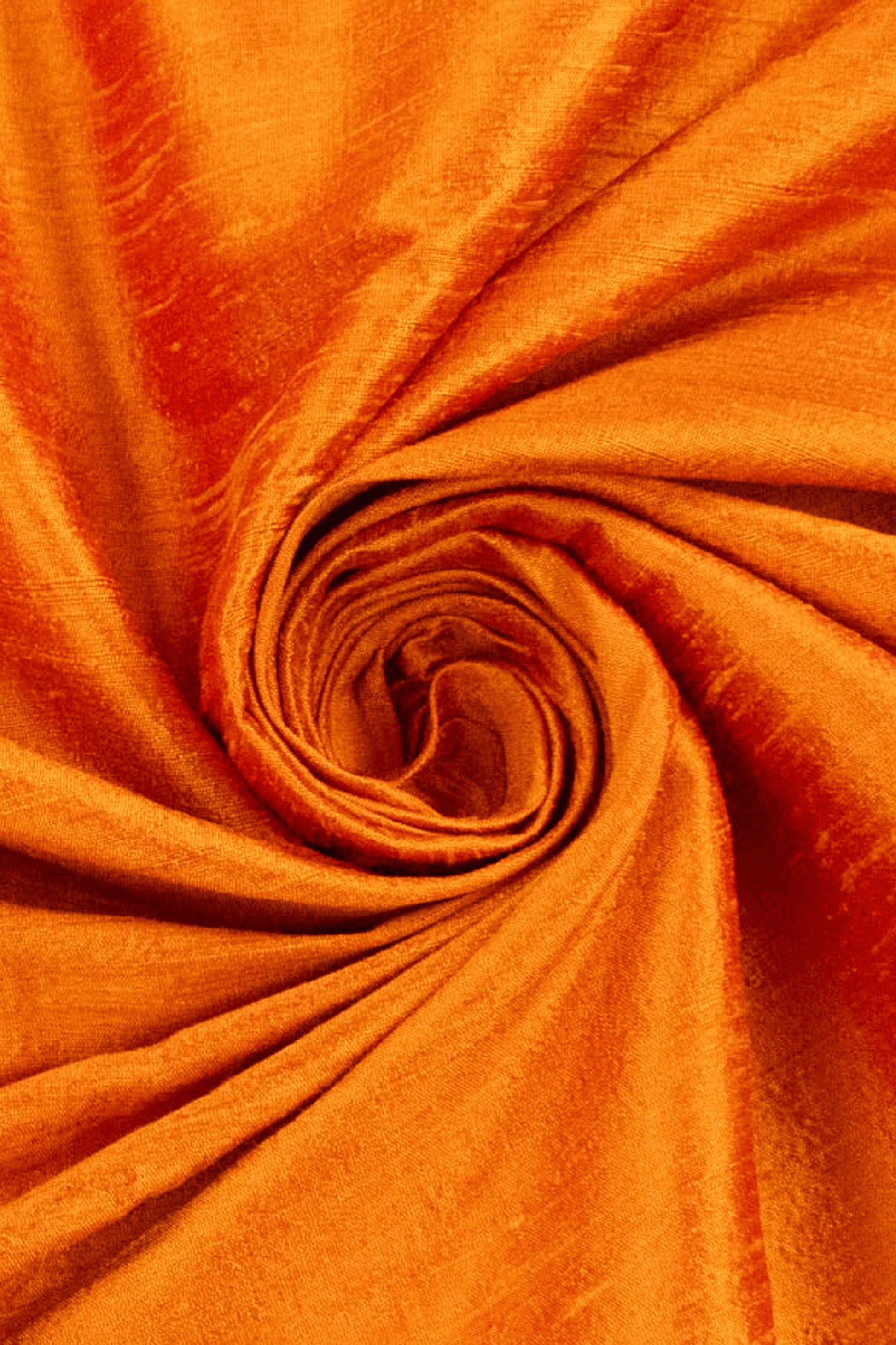 Close-up of orange raw silk fabric with a swirl pattern