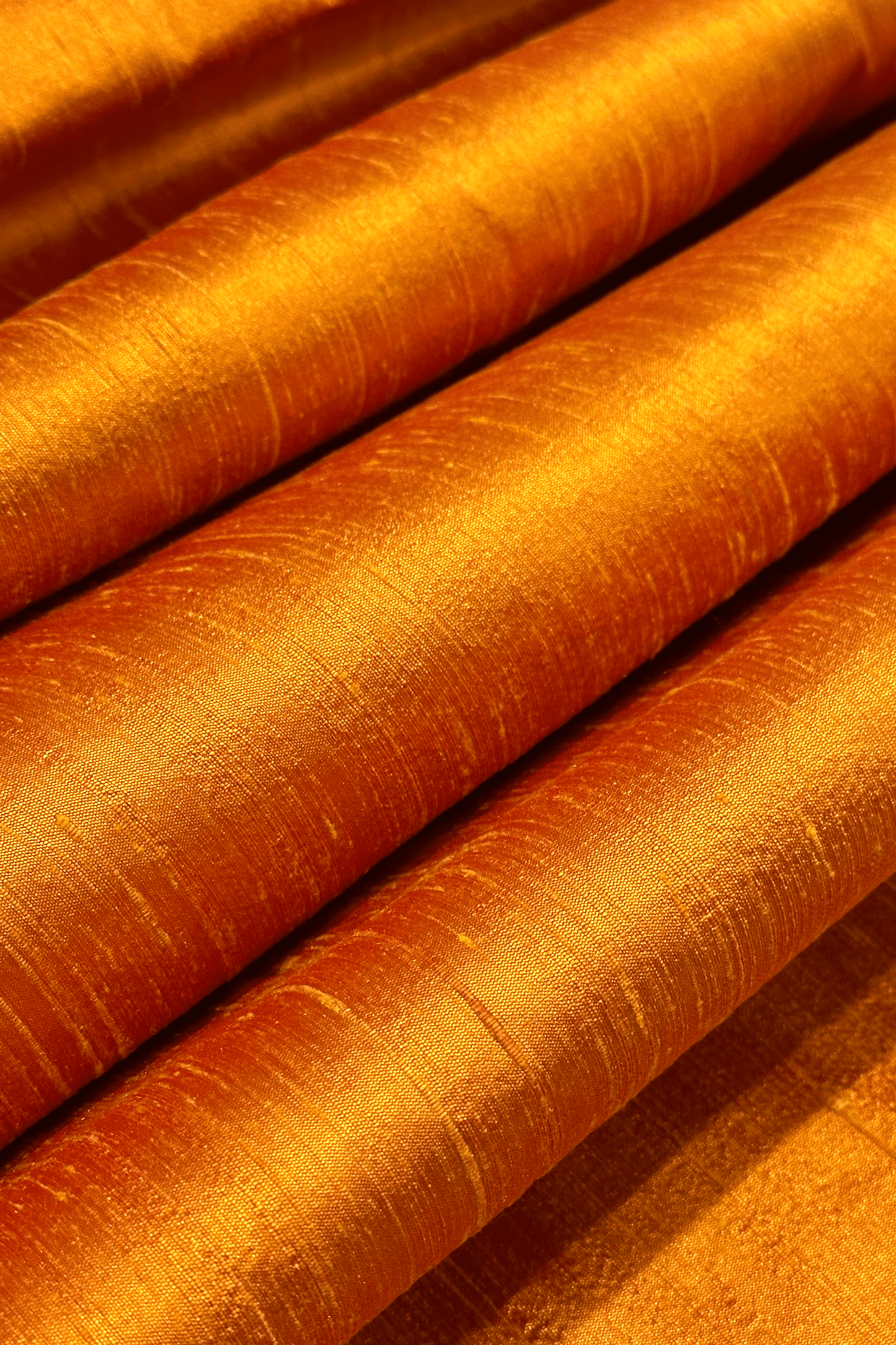 Close-up of orange raw silk fabric with a textured surface