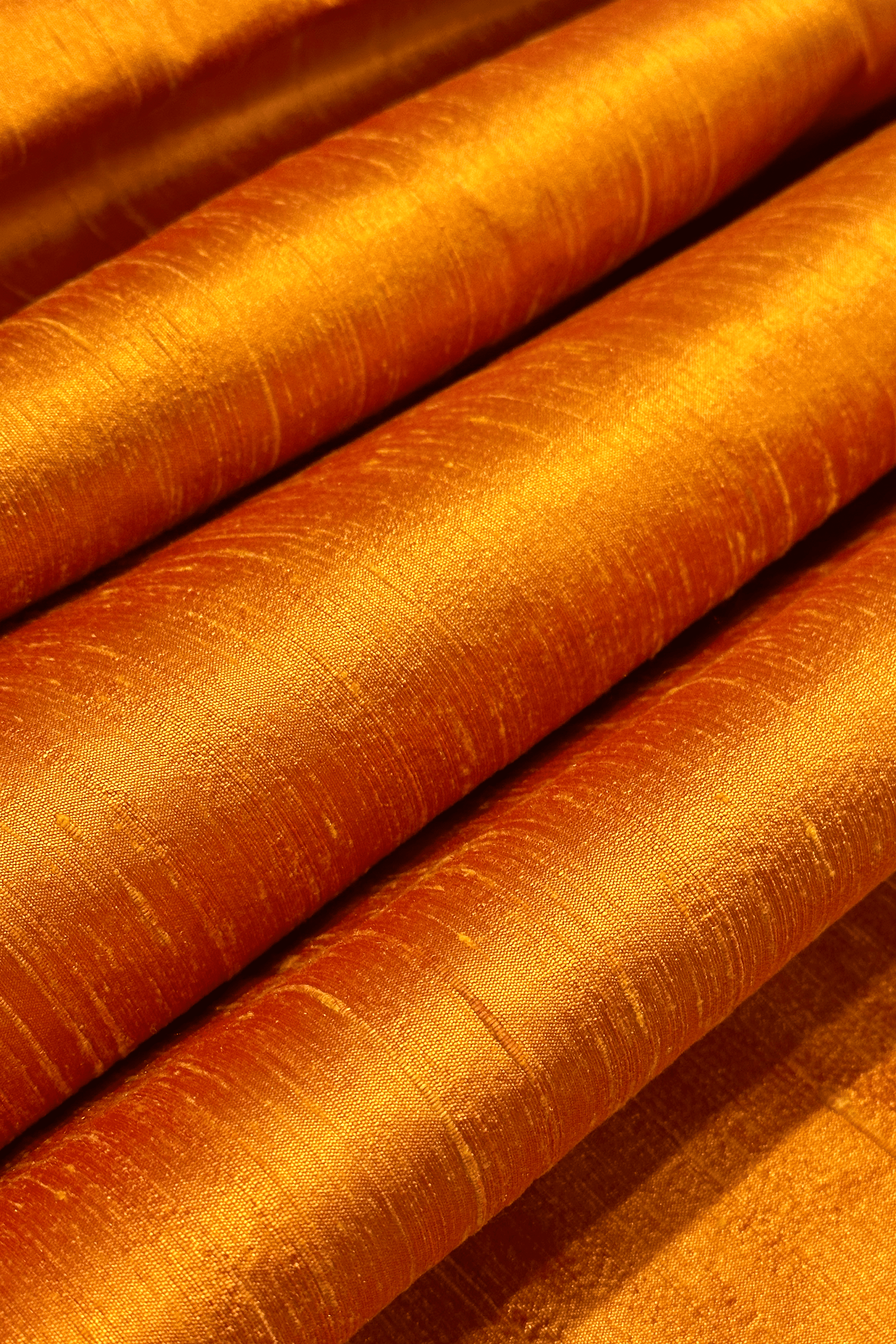 Close-up of orange raw silk fabric with a textured surface