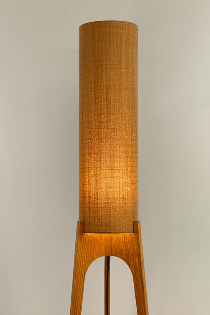 Mustard. Archie Rocket Floor Lamp - a handcrafted wooden floor lamp with a cylindrical shade in a mustard colour in a minimalist room.