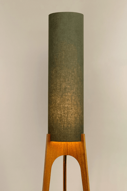 Handmade wooden Rocket Floor Lamp with cylindrical lampshade in Olive and wooden base in a mid-century room setting