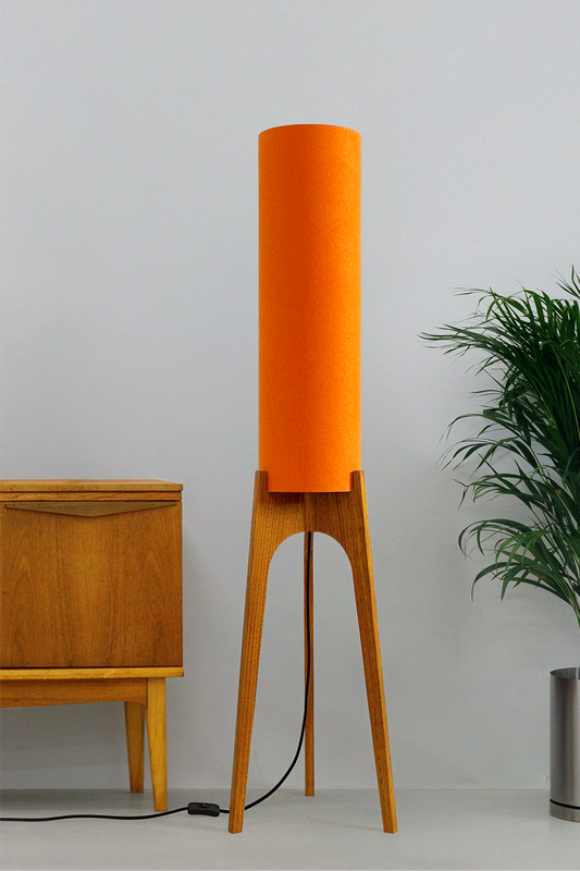 Orange - Archie Rocket Floor Lamp | Handmade by RETRO DUO with a cylindrical lampshade  and wooden lamp base next to a cabinet & plant