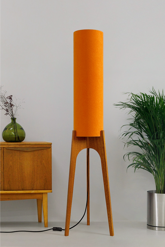 Orange - Archie Rocket Floor Lamp | Handmade by RETRO DUO with a cylindrical lampshade  and wooden lamp base next to a cabinet & plant