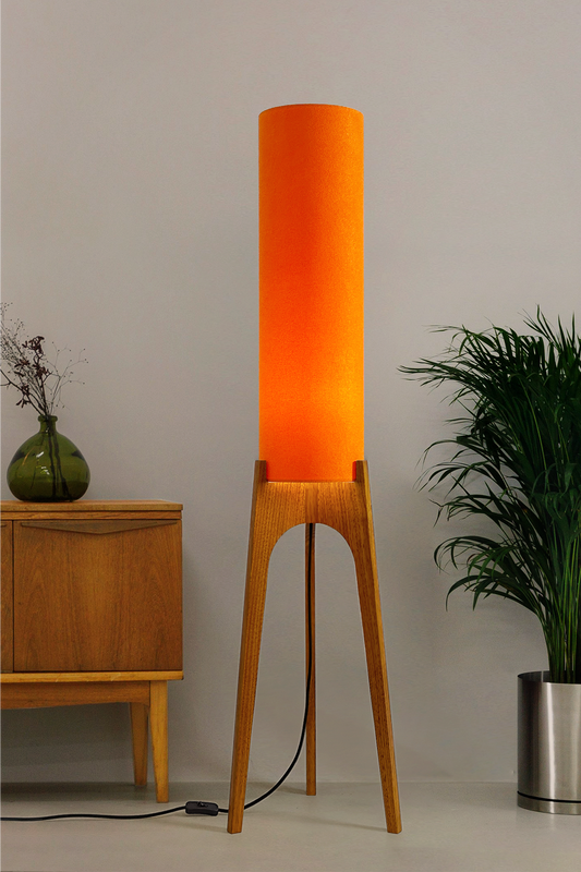 Orange - Archie Rocket Floor Lamp | Handmade by RETRO DUO with a cylindrical lampshade  and wooden lamp base next to a cabinet & plant