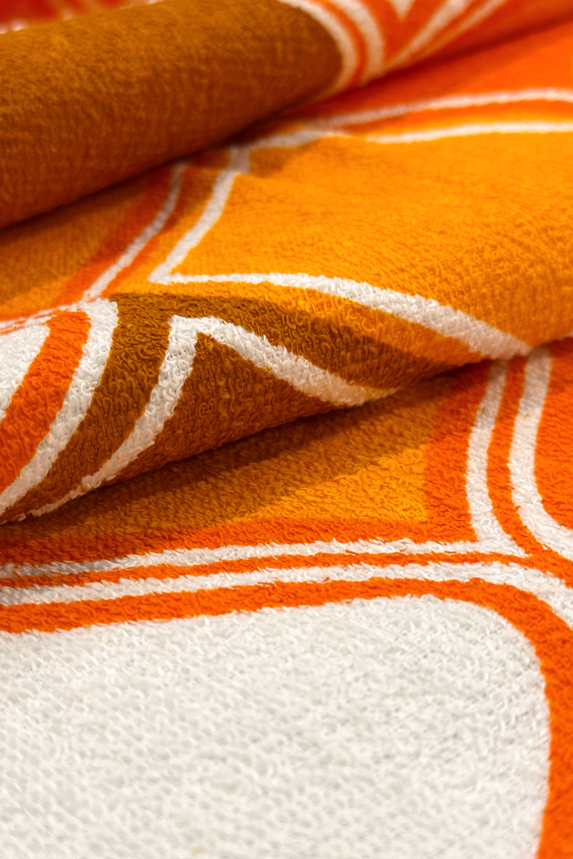 Close-up of Vintage Geometric patterned fabric with orange, brown, and white geometric design