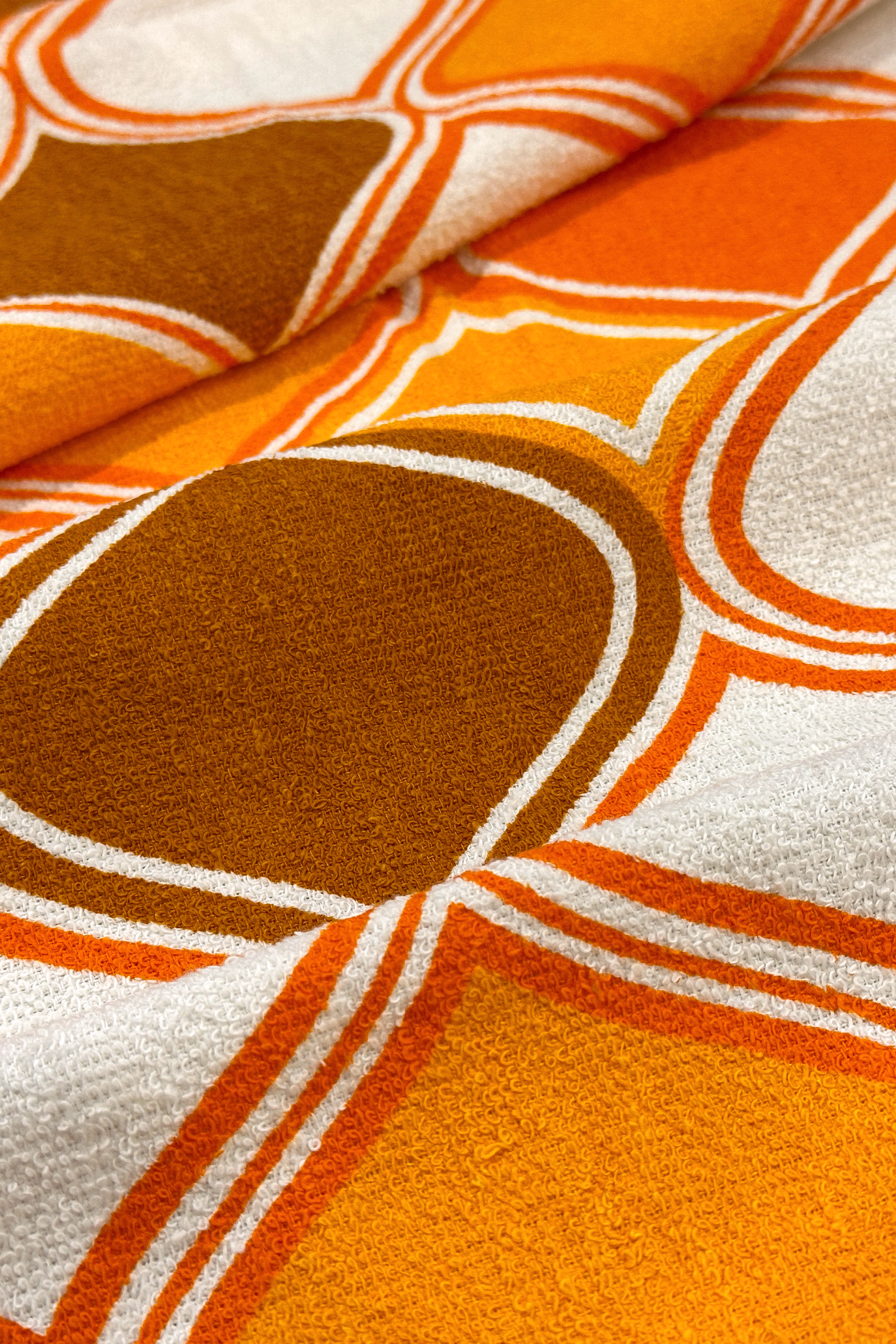 Close-up of Vintage Geometric patterned fabric with orange, brown, and white geometric design