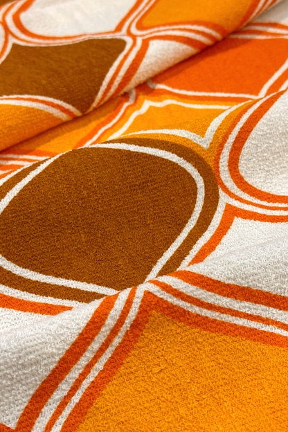 Close-up of Vintage Geometric patterned fabric with orange, brown, and white geometric design