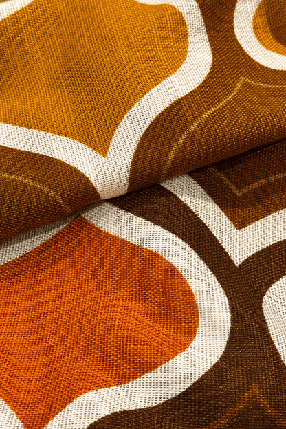 Patterned fabric with geometric design in brown, orange, and white.