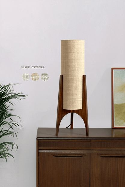 Archie Rocket Table lamp with wooden base and recycled fabric shade on with a plant and artwork in the background.