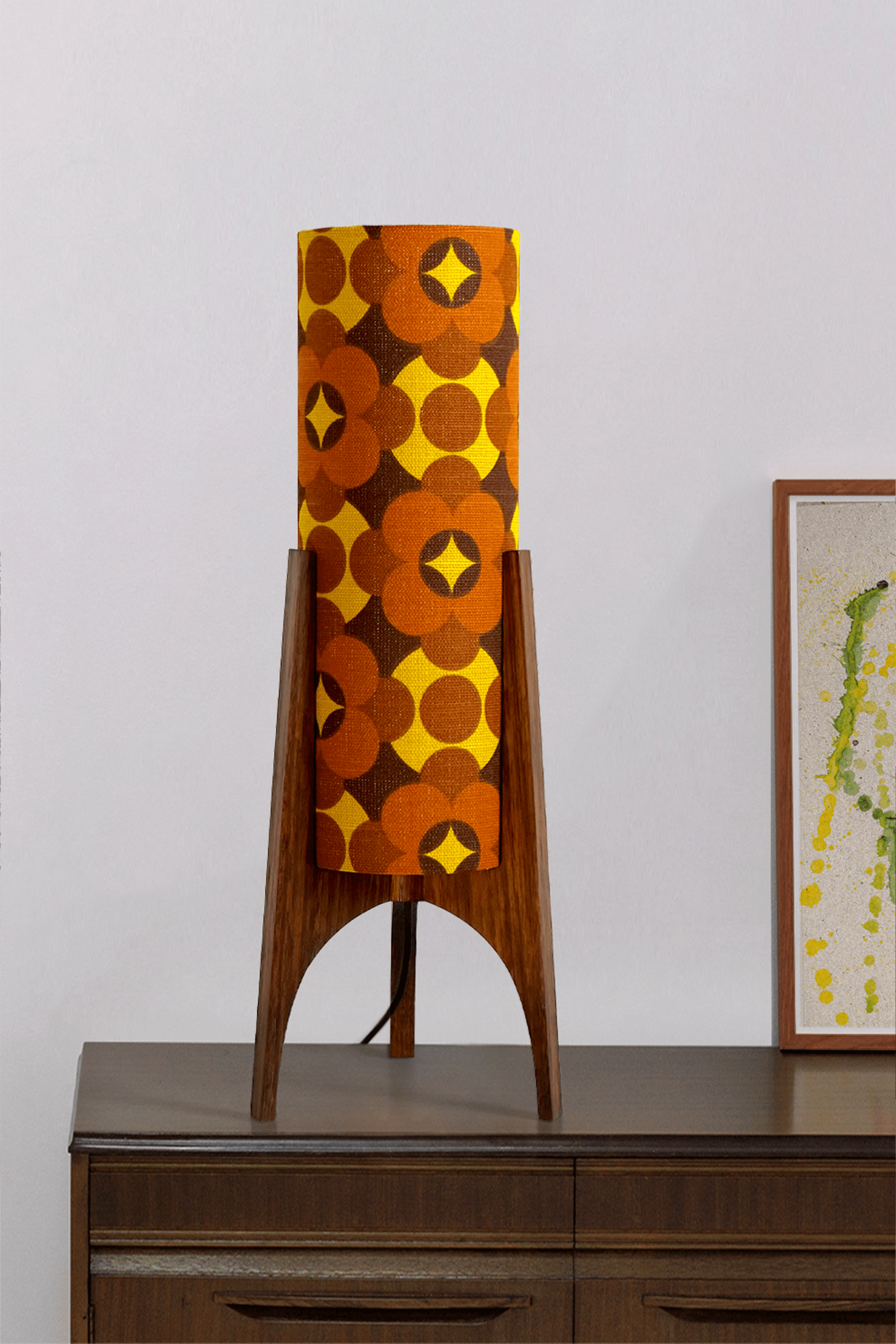 Coco - Archie Rocket Table lamp with a vintage geometric patterned fabric shade on a wooden cabinet against a white wall.