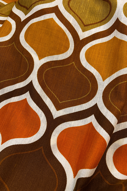 Patterned fabric with geometric design in brown, orange, and white on a black background